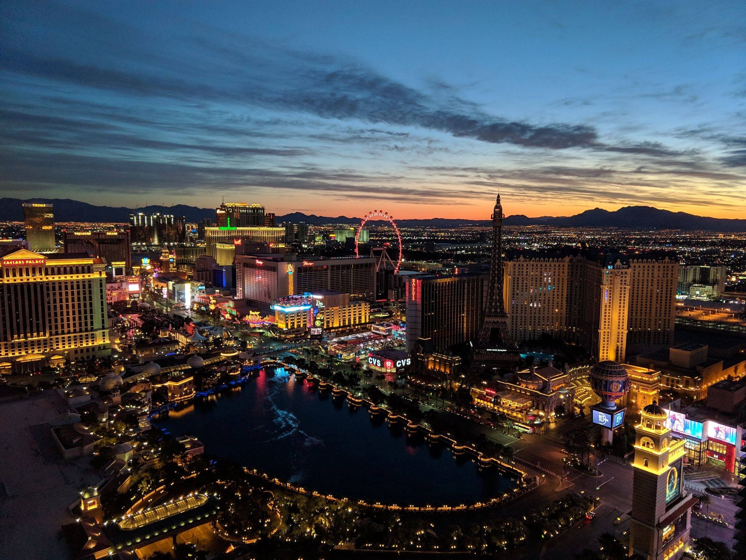 Aerial view of the Las Vegas Strip at dusk with the mountains behind